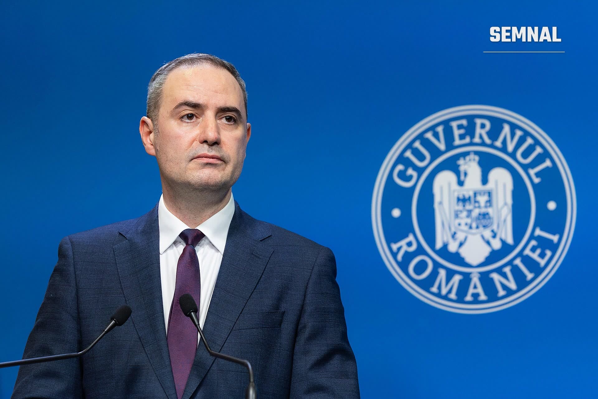 Alexandru Nazare, ministrul Finanțelor, la podiumul oficial de la Guvernul României, în costum bleumarin și cravată bordeie. (Foto: Octavianul)